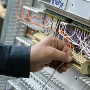 worker installing wiring in a control panel
